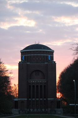 Die Sonne geht hinter dem Planetarium Hamburg unter. 